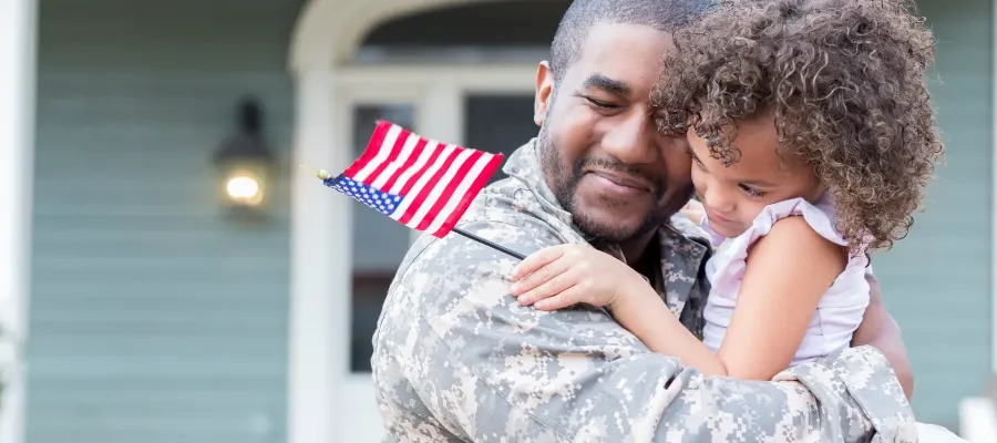 Military Dad Hugging Daughter Outside Of Home (1)